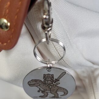 Captain Muffin Rides a T-Rex – Laser Engraved Adventure Cat Keychain Fob